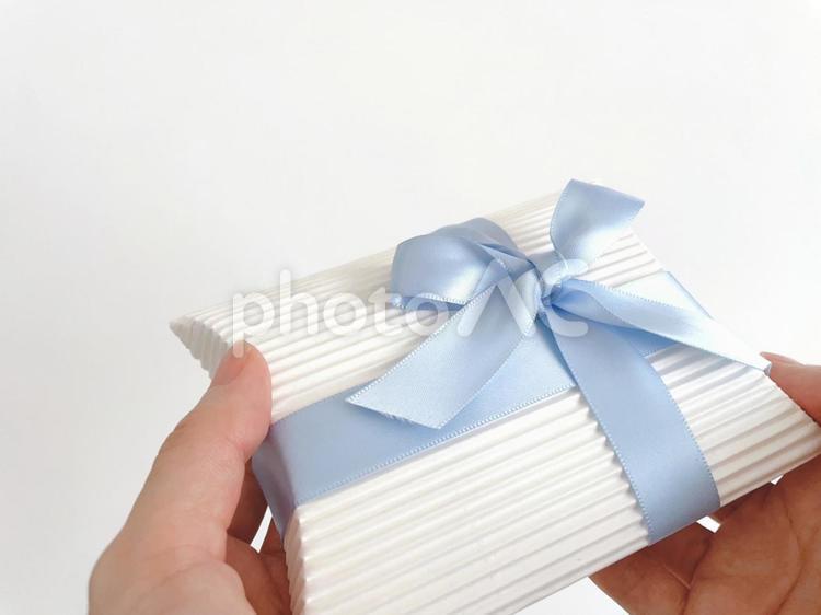 Female hand holding a blue ribbon gift, present, give a present, father's day gift, JPG