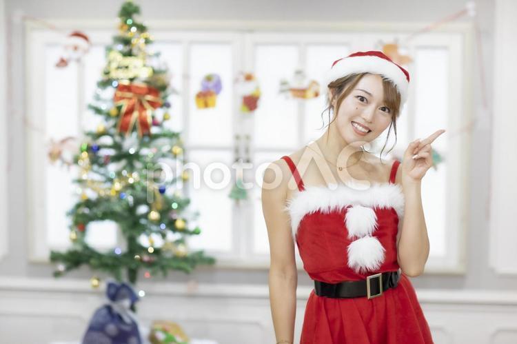 A woman in Santa's cosplay standing next to a Christmas tree, christmas, christmas party, women&#39;s christmas party, JPG