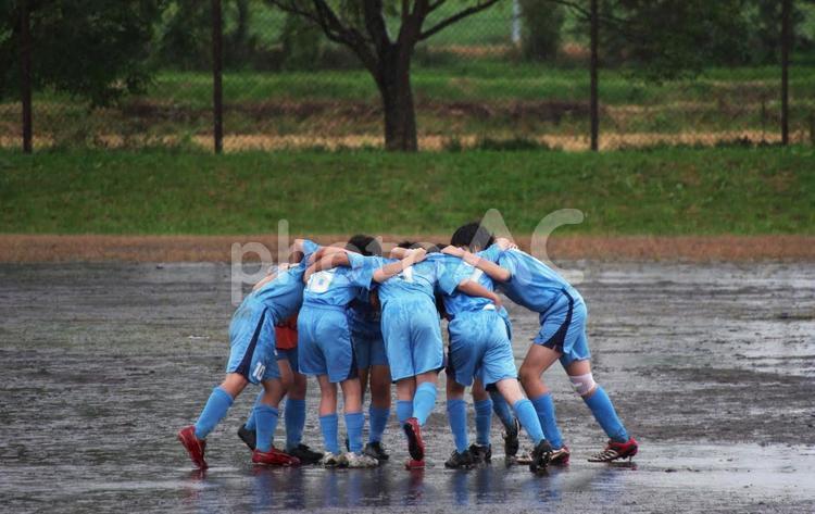 Boys forming a circle and getting excited in the rain at a soccer game, football, sports, rain, JPG