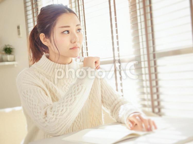 Image of a woman taking notes in a notebook, idea, to think about, to worry, JPG