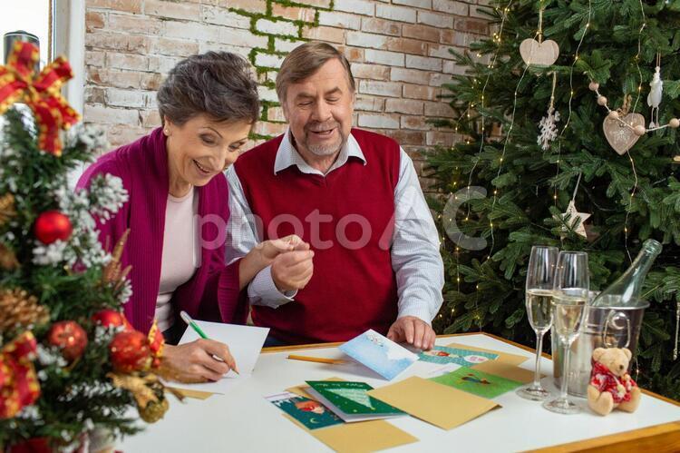 Elderly couple writing a Christmas card, after corona, with corona, old couple, JPG